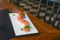 Salmon sushi rolls served on a white plate with ginger and wasabi and soy sauce in a restaurant table. Japanese cuisine. Royalty Free Stock Photo