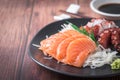 Salmon and Tako sashimi on black dish with chopsticks, Japanese food