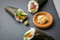 Salmon, tuna fish and Surimi avocado Temaki sushi with pickled ginger and wasabi on slate plate and marble background Royalty Free Stock Photo