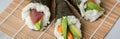 Salmon, tuna fish and Surimi avocado Temaki sushi with soy sauce, pickled ginger and wasabi on mat and marble background Royalty Free Stock Photo