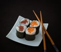 Salmon, tuna maki sushi and chopstick on black Royalty Free Stock Photo