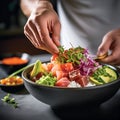 Salmon and tuna poke bowl. Close up of chef\'s hands cooking Poke bowl with tuna, salmon, avocado, edame beans and rice