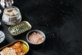 Salmon, tuna, trout mackerel and anchovy - Canned fish in tin cans, on black background, with copyspace  and space for text Royalty Free Stock Photo