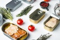 Salmon, tuna, trout mackerel and anchovy - Canned fish in tin cans, on white background with herbs and ingredients Royalty Free Stock Photo