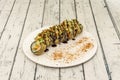 Salmon uramaki flambÃÂ©ed with tempura and nuts and vegetables on top. Soy sauce Royalty Free Stock Photo