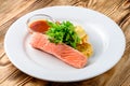 salmon with salad and vegetables - dish on a wooden background Royalty Free Stock Photo