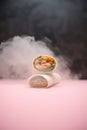 Delicious salmon wraps on pink backdrop with smoky effect for vibrant food promotions and captivating culinary visuals Royalty Free Stock Photo