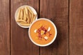 Salmorejo, Spanish cold tomato soup, overhead shot on a rustic wooden background with picos