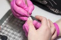 Salon manicure. Professional combined manicure in beauty salon. Manicurist in pink gloves uses special manicure tools. closeup of