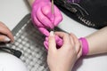 Salon manicure. Professional combined manicure in beauty salon. Manicurist in pink gloves uses special manicure tools. closeup of