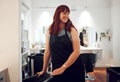 Salon, small business and happy hairdresser preparing or getting ready for work at her station. Happiness, smile and Royalty Free Stock Photo