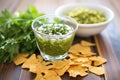 salsa verde in a glass dish, corn chips nearby