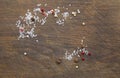Salt and colorful peas of pepper are scattered on the brown wooden kitchen Board Royalty Free Stock Photo