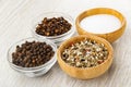 Salt, condiment in bamboo bowls, clove spice and peppercorn in bowls on table