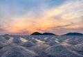 Salt farm in the morning with sunrise sky over the mountain. Organic sea salt. Evaporation and crystallization of sea water. Raw m