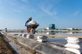 Salt farmer pushing wheelbarrow full of salt