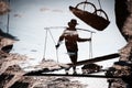 Salt farmers carry salt into the shed