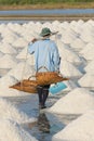 Salt farmers carry salt into the shed