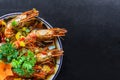 Salt fried shrimp with sauce and vegetables isolated on black backround