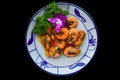 Salt fried shrimp with sauce and vegetables isolated on black backround