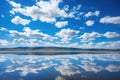 salt lagoon reflecting a deep blue sky and puffy white clouds
