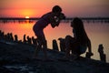 On a salt lake two girls take pictures of each other