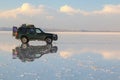 Salt Lake Uyuni in Bolivia. off road vehicle over a reflective salt flat ground