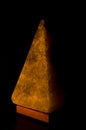 Salt lamp in the form of a pyramid in the darkness