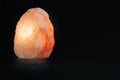 Salt lamp isolated against a black background. Mindfulness concept and esoterism. Empty copy space