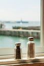 Salt and papper shaker s at ocean view restaurant window Royalty Free Stock Photo