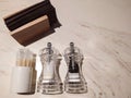 Salt and pepper in glass salt shakes, holder with napkins on a marble table. View from above Royalty Free Stock Photo