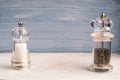 Salt and pepper grinders on a wooden background Royalty Free Stock Photo