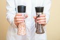 Salt and pepper mills in hands Royalty Free Stock Photo