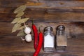 Salt and pepper shaker with bay leaf and red chili pepper, white garlic on background of wood, top view of the workspace Royalty Free Stock Photo