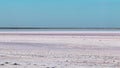 Salt pink lake surface under blue sunny sky