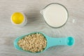 Salt, pitcher with milk, blue spoon with oat flakes on wooden table. Top view Royalty Free Stock Photo