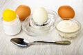 Salt, brown boiled eggs, peeled egg on egg stand, bowl with mayonnaise, spoon on wooden table Royalty Free Stock Photo