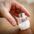 Salt shaker taken by male hand Royalty Free Stock Photo