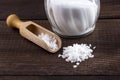 Salt spoon and saltshaker on wooden table