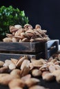 Salted almonds in shell. Delicious appetizer. Nuts in a wooden box. A large number of nuts are scattered on the table. Out of Royalty Free Stock Photo