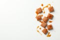 Salted caramel candies and sauce on white background Royalty Free Stock Photo