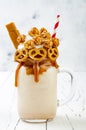 Salted caramel indulgent exreme milkshakes with brezel waffles, popcorn and whipped cream. Crazy freakshake trend Royalty Free Stock Photo