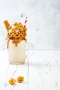 Salted caramel indulgent extreme milkshakes with brezel waffles, popcorn and whipped cream. Crazy freakshake trend