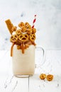 Salted caramel indulgent extreme milkshakes with brezel waffles, popcorn and whipped cream. Crazy freakshake trend Royalty Free Stock Photo