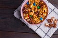 Salted dark chocolate popcorn with colorful chocolate buttons in bowl on napkin. Royalty Free Stock Photo