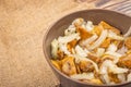 Salted mushrooms in a ceramic bowl, a glass of vodka and a decanter on a background of rough homespun fabric. Homemade blanks. Royalty Free Stock Photo