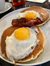 Salted Pancakes with Hollandaise Sauce, Eggs and Crispy Bacon for Breakfast. Salty Organic Fast Food Royalty Free Stock Photo