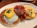 Salted Pancakes with Hollandaise Suace, Eggs and Crispy Bacon for Breakfast. Salty Organic Fast Food served at restaurant. Royalty Free Stock Photo