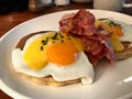 Salted Pancakes with Hollandaise Suace, Eggs and Crispy Bacon for Breakfast. Salty Organic Fast Food served at restaurant. Royalty Free Stock Photo