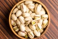 Salted Pistachio nuts in wooden bowl